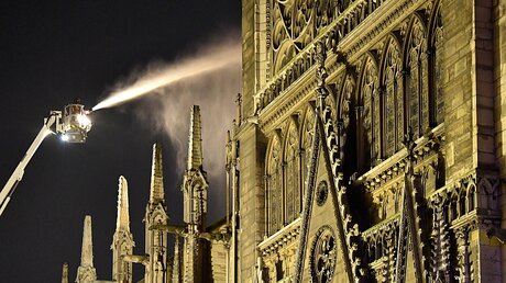 Ein Feuerwehrmann versucht, das Feuer in der Kathedrale Notre-Dame zu löschen / © Julien Mattia (dpa)