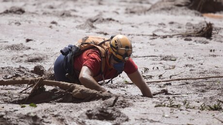 Ein Helfer sucht nach dem Dammbruch nach Überlebenden / © O Globo/GDA via ZUMA Wire (dpa)