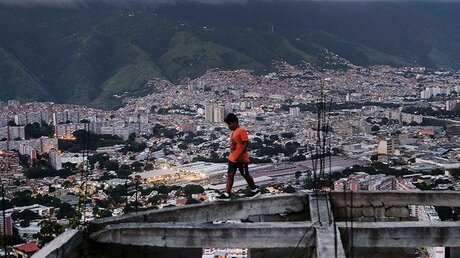 Ein Junge geht über ein unfertiges Haus in Caracas, Venezuela / © Matias Delacroix (dpa)