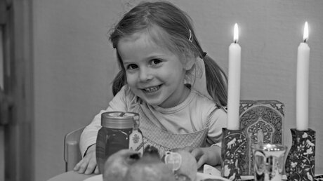 Ein Kind an einem für das jüdische Neujahrsfest (Rosch Haschana) gedeckten Tisch / © Rafael Herlich (privat)