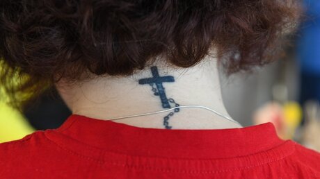 Ein Rosenkranz-Tattoo auf dem Nacken einer Frau als Zeichen ihrer Gläubigkeit. / © Harald Oppitz (KNA)
