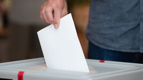 Ein Wähler wirft bei der Landtagswahl in Sachsen-Anhalt seinen Stimmzettel in die Wahlurne / © Sebastian Kahnert (dpa)