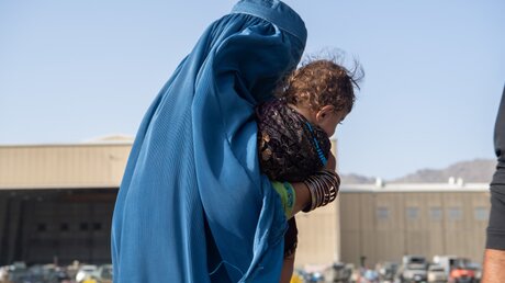 Eine afghanische Frau trägt ein Kind auf dem Arm  / © Msgt. Donald R. Allen/U.S. Air (dpa)