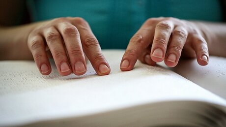 Eine blinde Frau liest ein Buch in Brailleschrift in der Deutschen Zentralbücherei für Blinde (DZB) / © Markus Nowak (KNA)