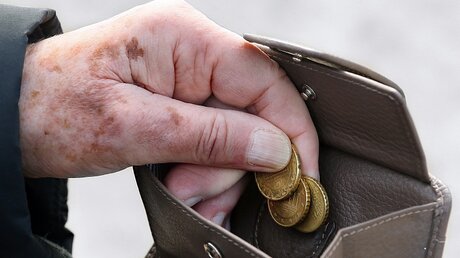 Eine Frau holt Münzen aus ihrem Portemonnaie / © Stephanie Pilick (dpa)