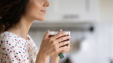 Eine Frau genießt Auszeit mit Tee-Tasse in der Hand / © fizkes (shutterstock)