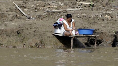  Eine Frau wäscht ihre Kleider am Amazonas in Leticia, am Drei-Ländereck Kolumbien, Peru und Brasilien / © Fernando Vergara (dpa)
