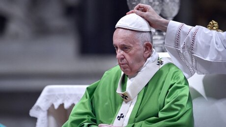 Eine Hand greift nach dem Pileolus von Papst Franziskus / © Stefano Spaziani (KNA)