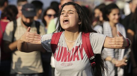 Eine junge Frau ruft Slogans gegen die libanesische Regierung / © Hassan Ammar (dpa)