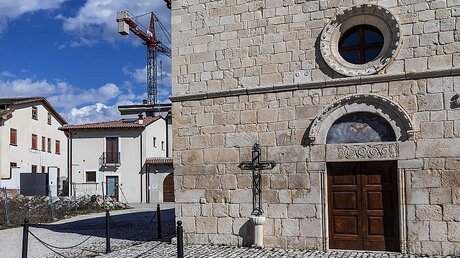 Eine Kirche vor einem Baukran in L'Aquila / © Stefano dal Pozzolo (KNA)