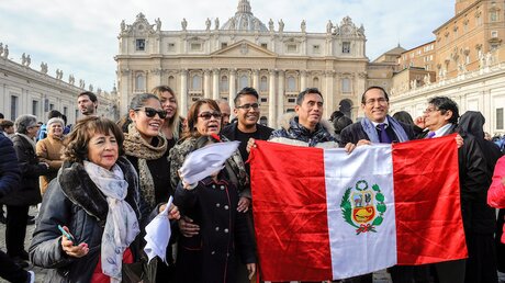Eine Menschengruppe auf dem Petersplatz hält eine peruanische Flagge hoch / © Paolo Galosi/Romano Siciliani (KNA)