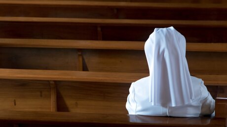 Eine Nonne sitzt in der Kirche / © Milkovasa (shutterstock)