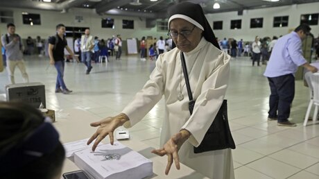 Eine Nonne zeigt den Wahlhelfern ihre Finger während der Präsidentschaftswahlen in El Salvador / © Moises Castillo (dpa)