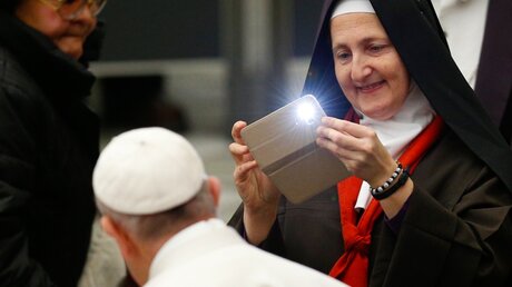 Eine Ordensfrau macht ein Handyfoto vom Papst / © Paul Haring (KNA)
