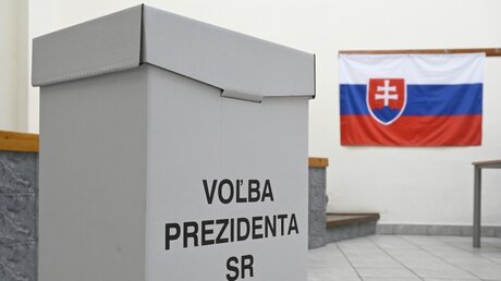 In einem Wahllokal hängt die slowakische Flagge an der Wand / © Radovan Stoklasa (dpa)