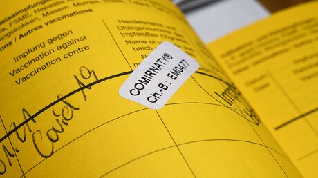 Eintragung der Corona-Imfpung im gelben Impfpass. / © nitpicker (shutterstock)