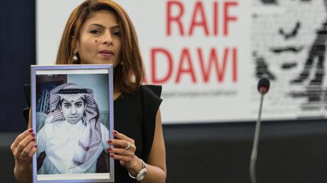Die Frau des inhaftierten saudi-arabischen Bloggers Raif Badawi, Ensaf Haidar, zeigt im EU-Parlament in Straßburg ein Bild ihres Mannes / © Patrick Seeger (dpa)