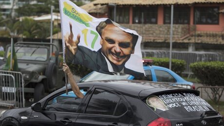 Fahne, die ein Bild von Bolsonaro zeigt / © Leo Correa (dpa)