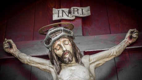 Figur des gekreuzigten Jesus mit "INRI"-Schriftzug / © KYNA STUDIO (shutterstock)