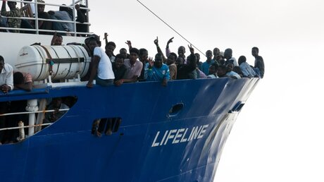 Flüchtlinge stehen am Bug des Rettungsschiffes Lifeline / © Hermine Poschmann (dpa)