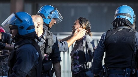 Ein Polizist tröstet eine Frau nach den Ausschreitungen in Rom / © Angelo Carconi (dpa)