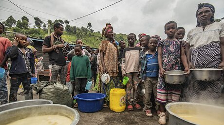 Geflüchtete aus Goma versammeln sich an einer Lebensmittelverteilungsstelle in Sake, wo sie Unterschlupf gefunden haben. / © Moses Sawasawa/AP (dpa)