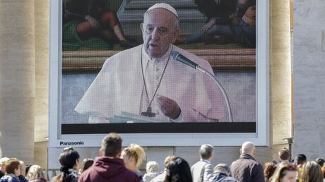 Gläubige nehmen an der Live-Übertragung des Angelus-Gebetes von Papst Franziskus auf dem Petersplatz teil.  / © Andrew Medichini (dpa)