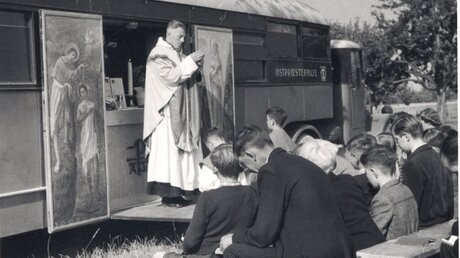 Gottesdienst vor einem Kapellenwagen von "Kirche in Not" (KiN)