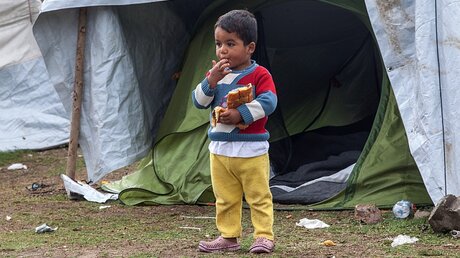 Flüchtlingskind vor einem Zelt / © EPA/NIKOS ARVANITIDIS (dpa)
