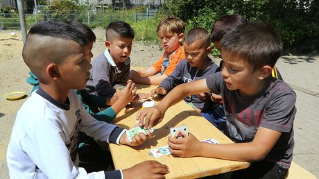 Flüchtlingskinder spielen Karten (epd)