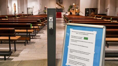 Hinweistafel und Desinfektionsmittel in einer Kirche / © Harald Oppitz (KNA)