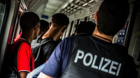 Polizist begleitet Flüchtlinge / © Nicolas Armer (dpa)
