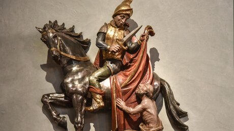 Der heilige Martin sitzt auf einem Pferd und teilt seinen Mantel mit einem Bettler. / © Harald Oppitz (KNA)