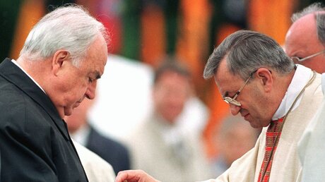 Bundeskanzler Helmut Kohl (l.) empfängt die Kommunion von Bischof Karl Lehmann beim Katholikntag 1998 in Mainz (KNA)