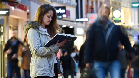 Ein Frau liest auf der Straße in der Bibel / © Harald Oppitz (KNA)