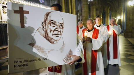 Priester tragen eine Zeichnung mit dem Abbild des ermordeten Priesters Jacques Hamel / © Corinne Simon (KNA)