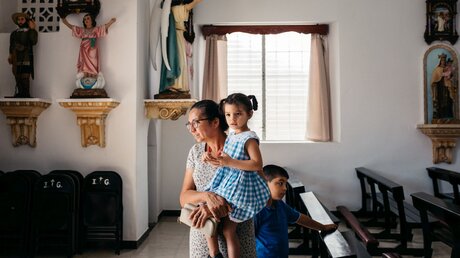  Mutter mit Kindern in einer Kirche  / © Jean-Matthieu Gautier (KNA)
