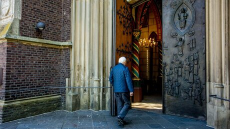 Ein Mann betritt eine Kirche / © Theo Barth (KNA)