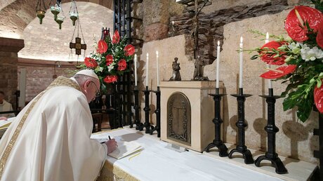 Papst Franziskus unterzeichnet 2020 die Enzyklika "Fratelli tutti" in der Basilika San Francesco in Assisi / © Vatican Media/Romano Siciliani (KNA)