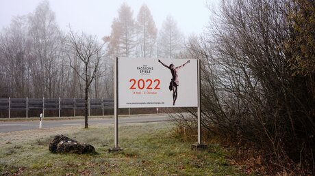 Ein Plakat an einer Straße in Oberammergau wirbt für die Passionspiele 2022 / © Dieter Mayr (KNA)