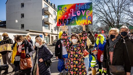 Eine kostümierte Demonstrantin während einer Demonstration gegen den Krieg in der Ukraine am Rosenmontag, den 28. Februar 2022, in Köln. / © Theodor Barth (KNA)