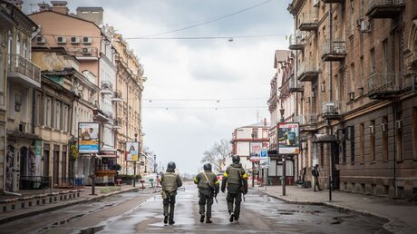 Bewaffnete Männer gehen in Odessa eine menschenleere Straße entlang / © Francesca Volpi (KNA)
