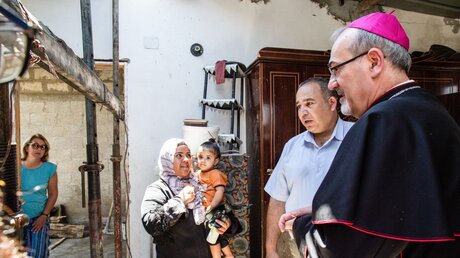 Erzbischof Pierbattista Pizzaballa spricht während eines Pastoralbesuches im Gazastreifen mit eine Familie (Archiv) / © Andrea Krogmann (KNA)