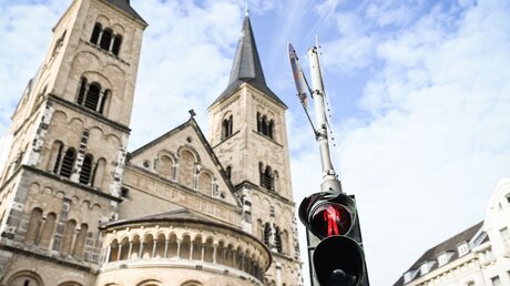 Symbolbild Kirchenaustritt: Eine Ampel vor einer Kirche zeigt rot / © Julia Steinbrecht (KNA)