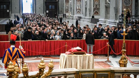 Menschen warten dicht gedrängt in einer langen Schlange hinter einer Absperrung, um Abschied zu nehmen vom aufgebahrten Leichnam des emeritierten Papstes Benedikt XVI.  / © Vatican Media/Romano Siciliani (KNA)