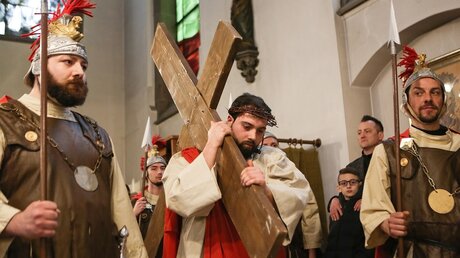 Angelo Caputo, Laiendarsteller des Jesus, trägt das Kreuz bei einem Passionspiel der Italienischen Katholischen Mission in der Kirche Sankt Marien in Köln-Kalk / © Adelaide Di Nunzio (KNA)