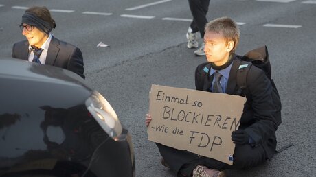 Aktivisten der letzten Generation sitzen auf einer Kreuzung an der Landsberger Allee in Berlin. / © Paul Zinken (dpa)