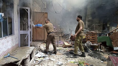 Polizisten in Pakistan versuchen ein brennendes Gebäude zu löschen / © Uncredited/District Police Office (dpa)