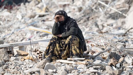 Ein Mensch sitzt in den Trümmern nach dem Erdbeben in der Türkei und Syrien / © Boris Roessler (dpa)