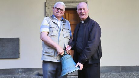 Generalvikar Assmann übergibt Lutz Ruhloff eine Glocke / © Stephan Hammers (Erzbistum Köln)